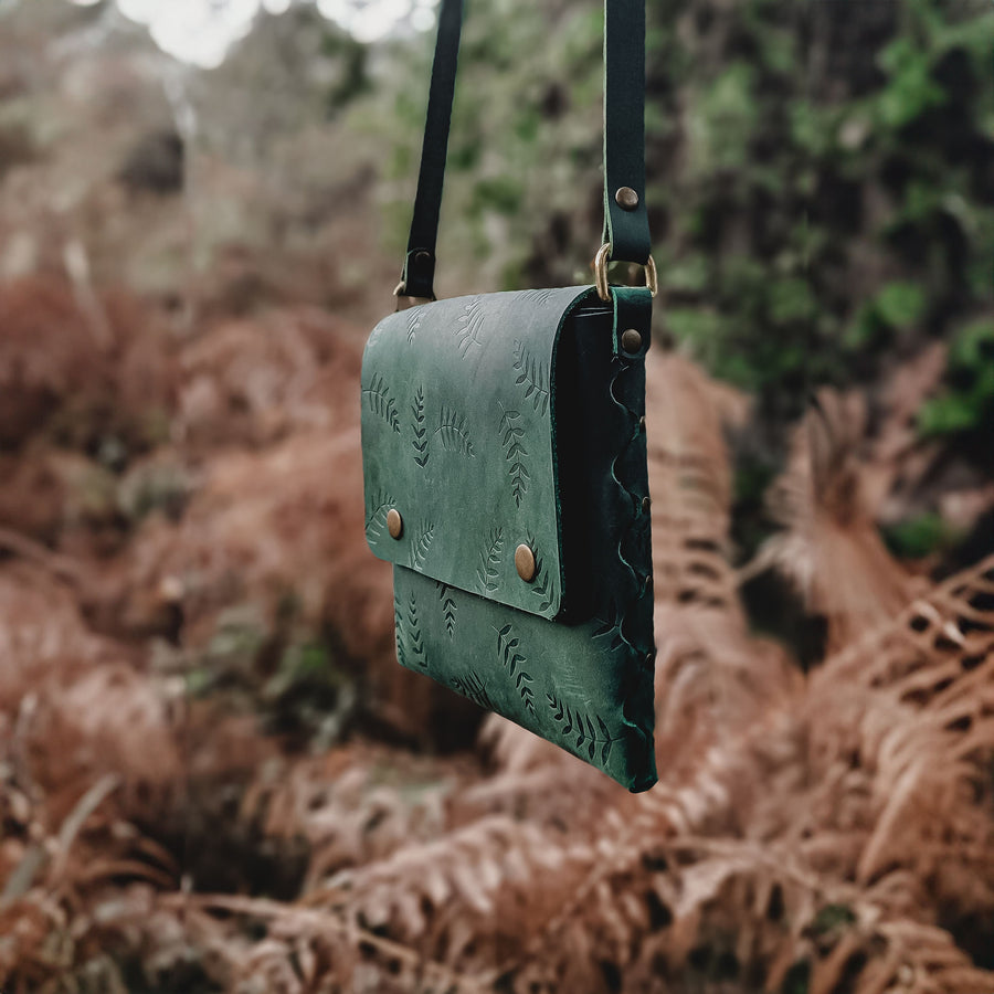 side photo of green leather botanical bag