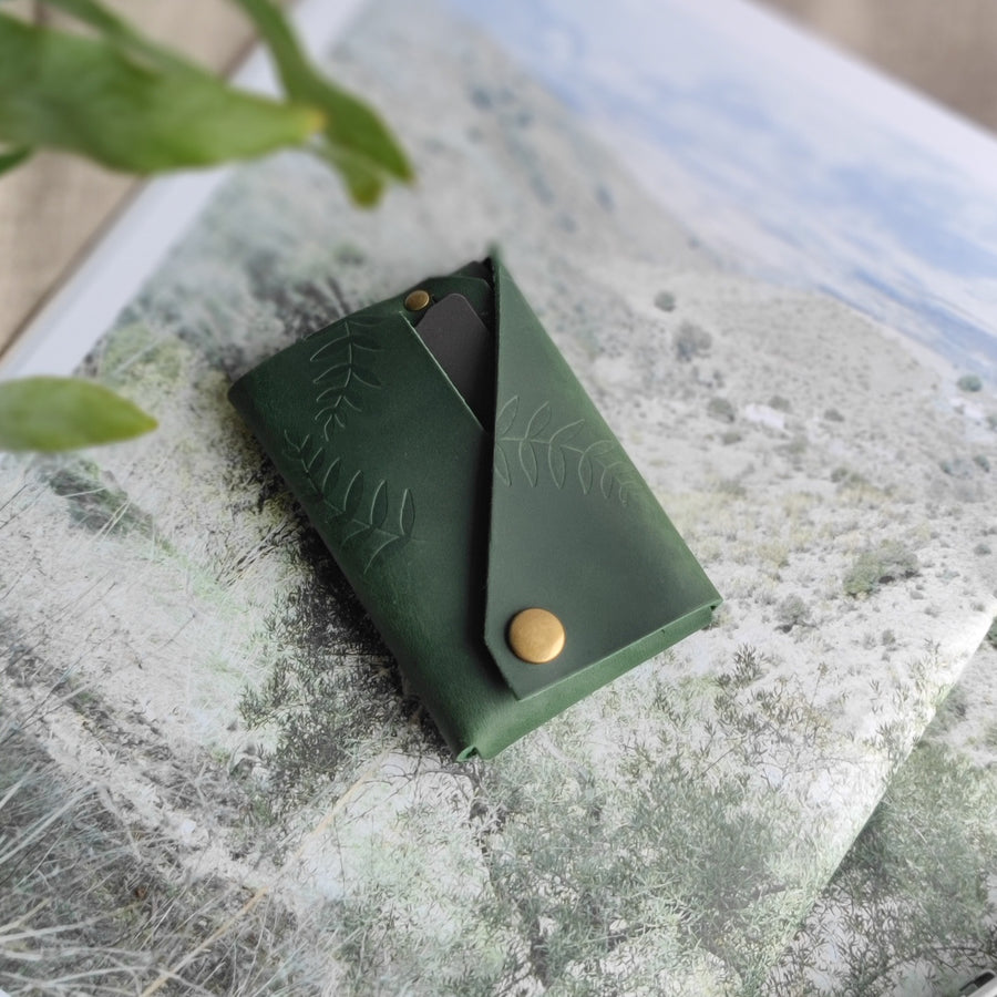 side photo of green botanical leather wallet