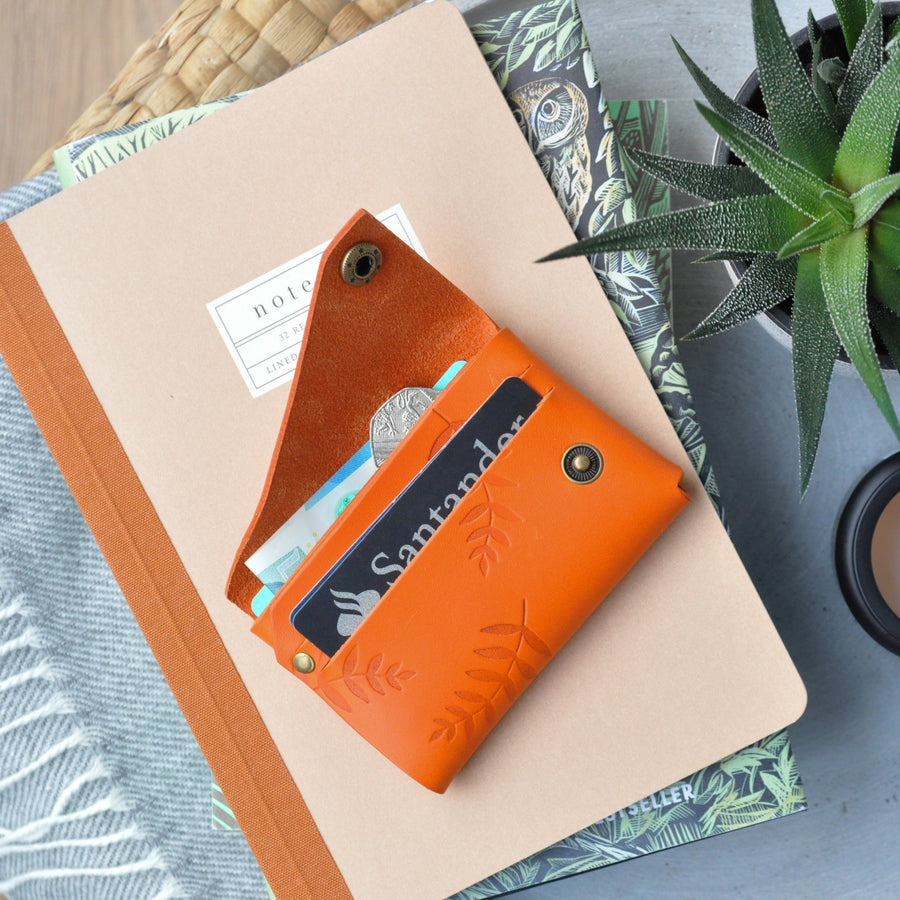 orange botanical leather wallet open and in use